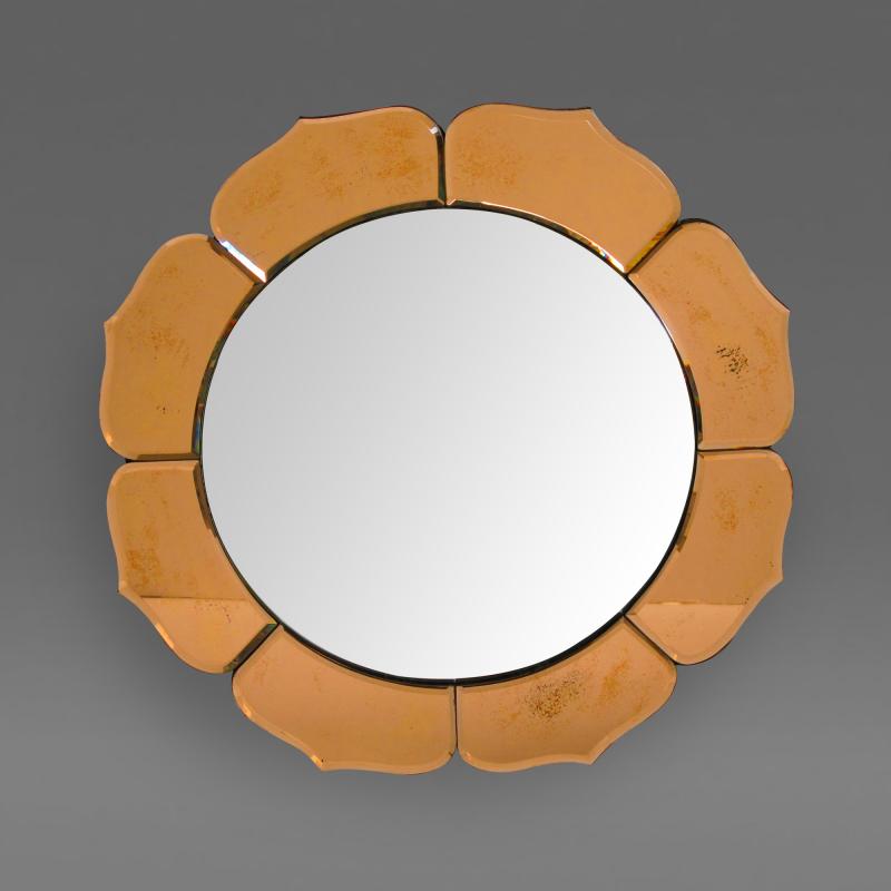 A French art deco convex mirror surrounded by peach colored petals