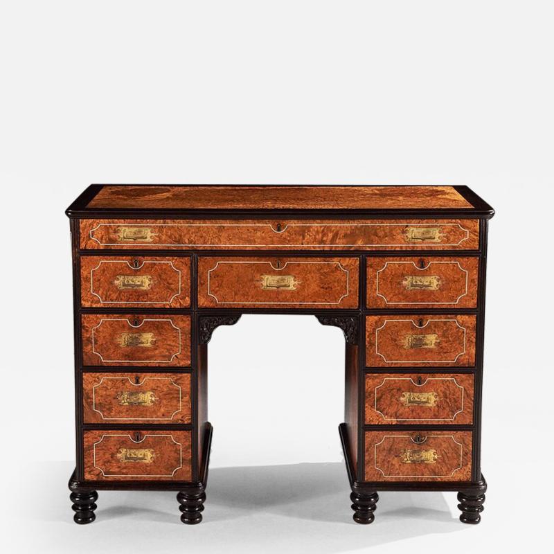 A RARE CHINESE EXPORT AMBOYNA AND EBONY CAMPAIGN KNEEHOLE DESK