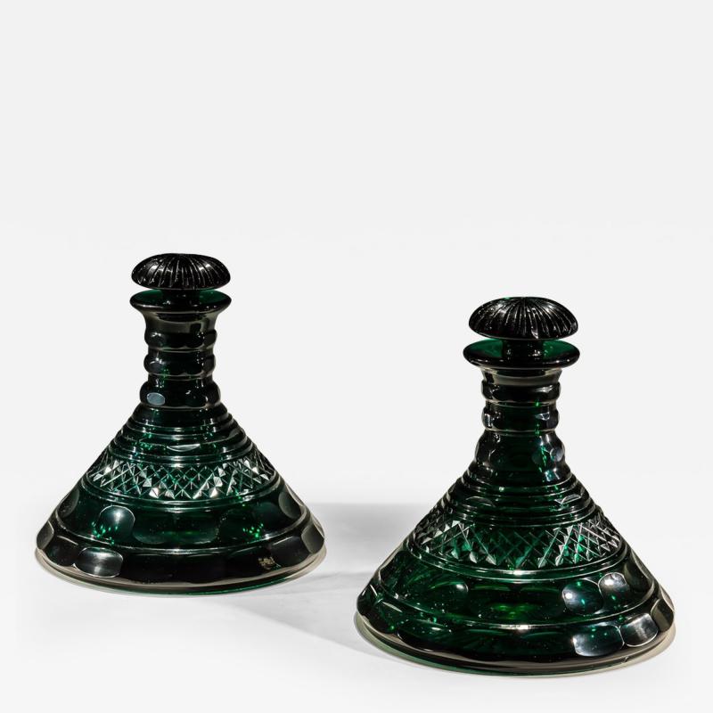 A RARE PAIR OF HEAVILY CUT EMERALD GREEN DECANTERS