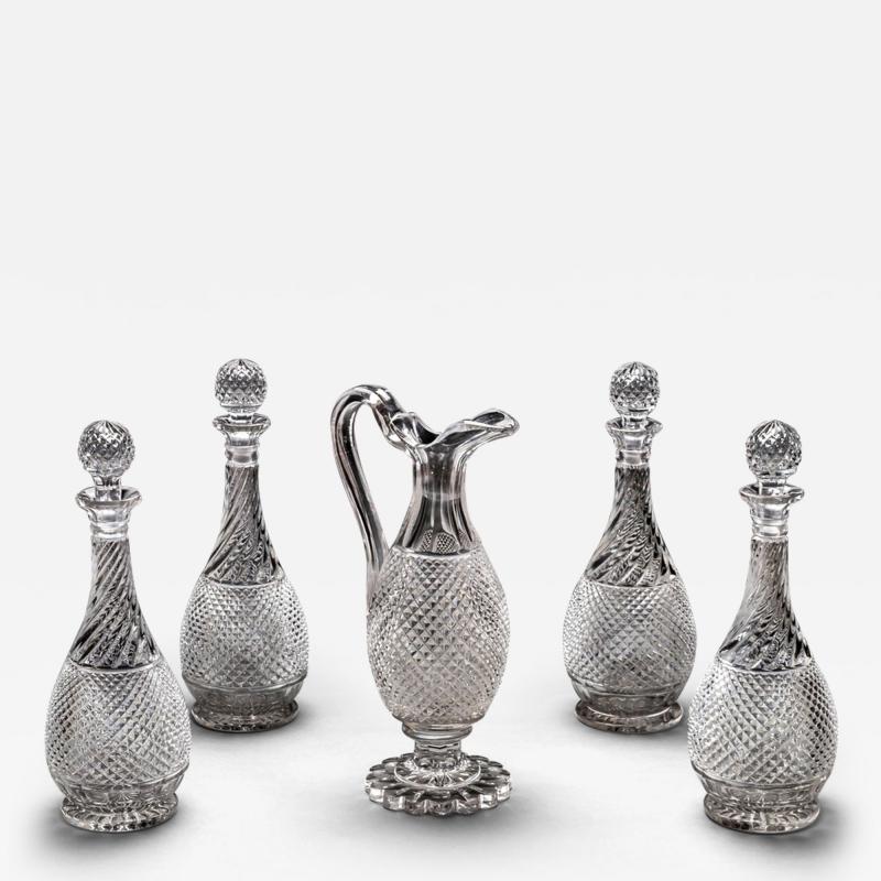 A SET OF FOUR DIAMOND SWIRL CUT DECANTERS WITH CORRESPONDING WINE EWER