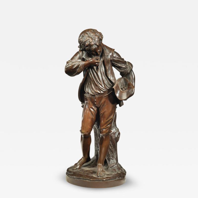 A bronze study of a boy collecting fruit in his wide brimmed hat