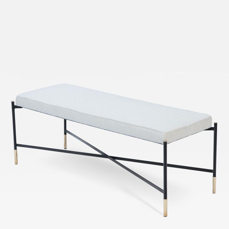 A contemporary Italian bench with cross stretchers and brass details 