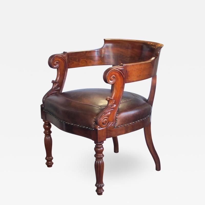 A dramatically carved French restoration barrel back desk chair