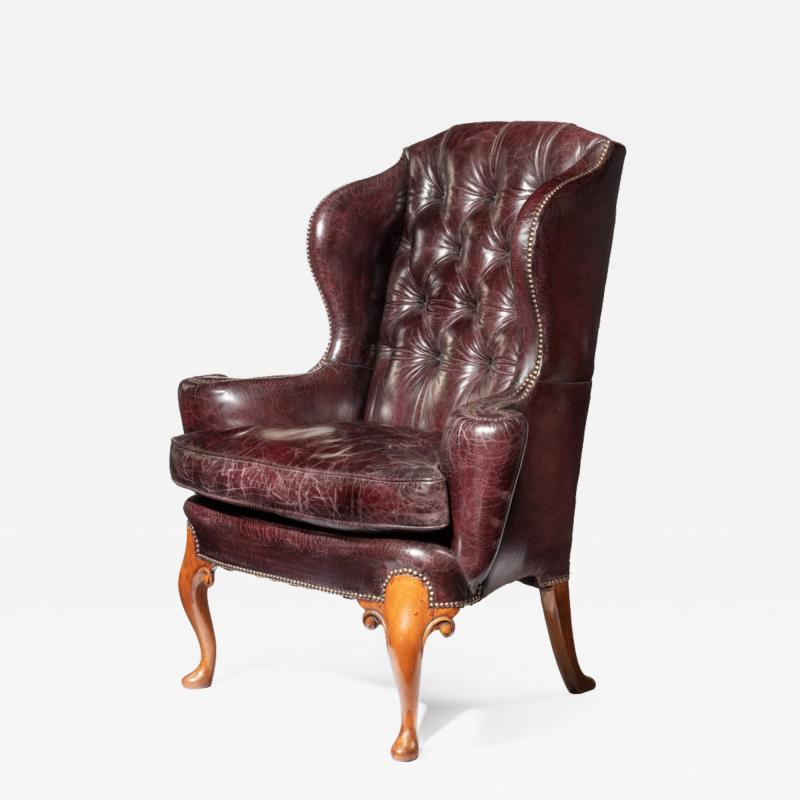 A large George I style burgundy leather wing arm chair