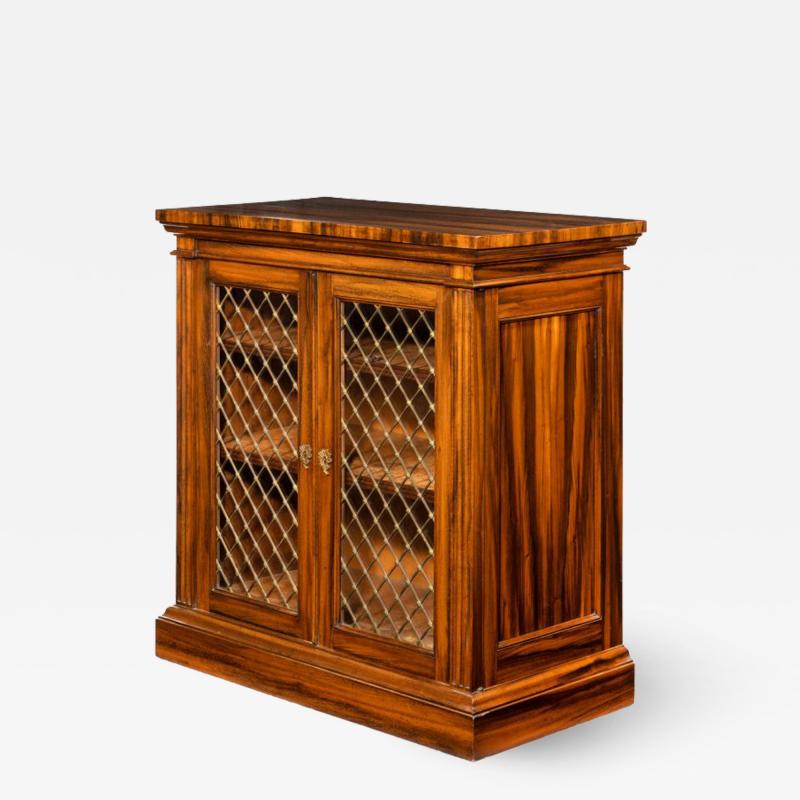 A late Regency Gon alo Alves two door side cabinet attributed to Gillows