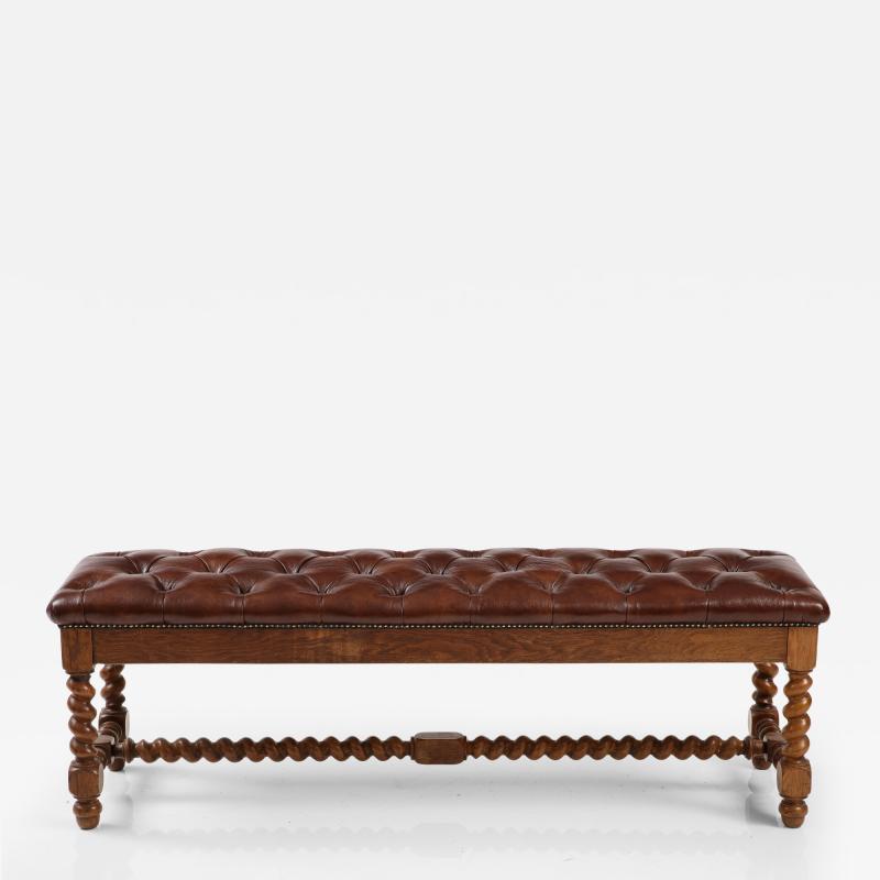 A long French oak bench with tufted leather upholstery