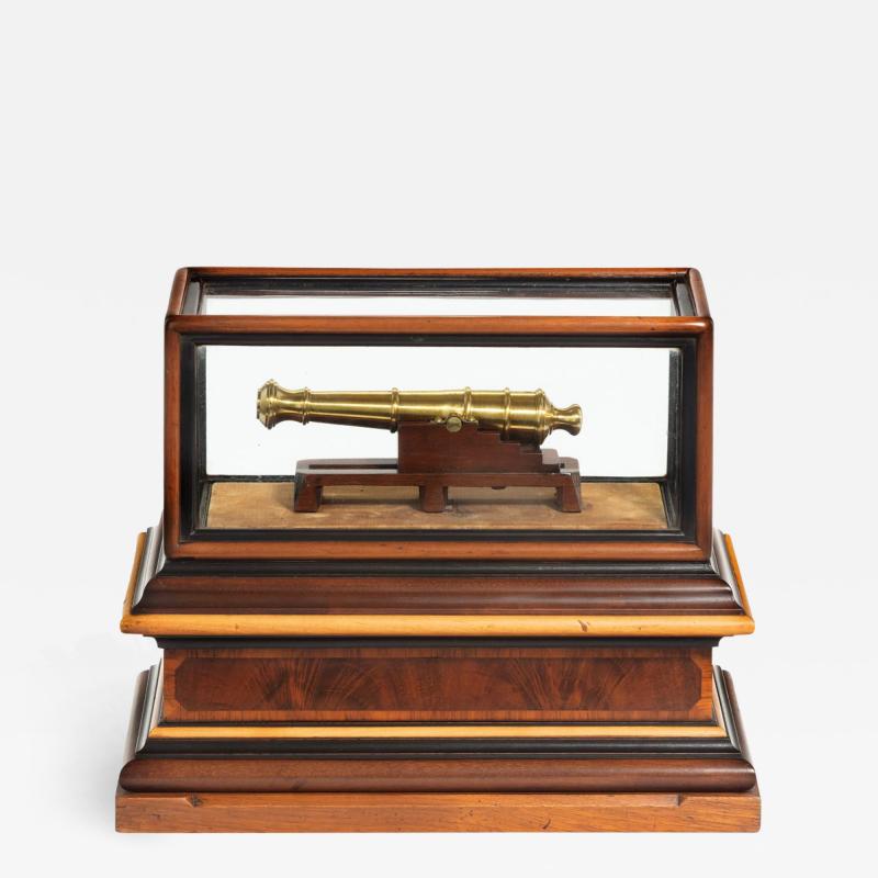 A miniature brass cannon in a presentation case