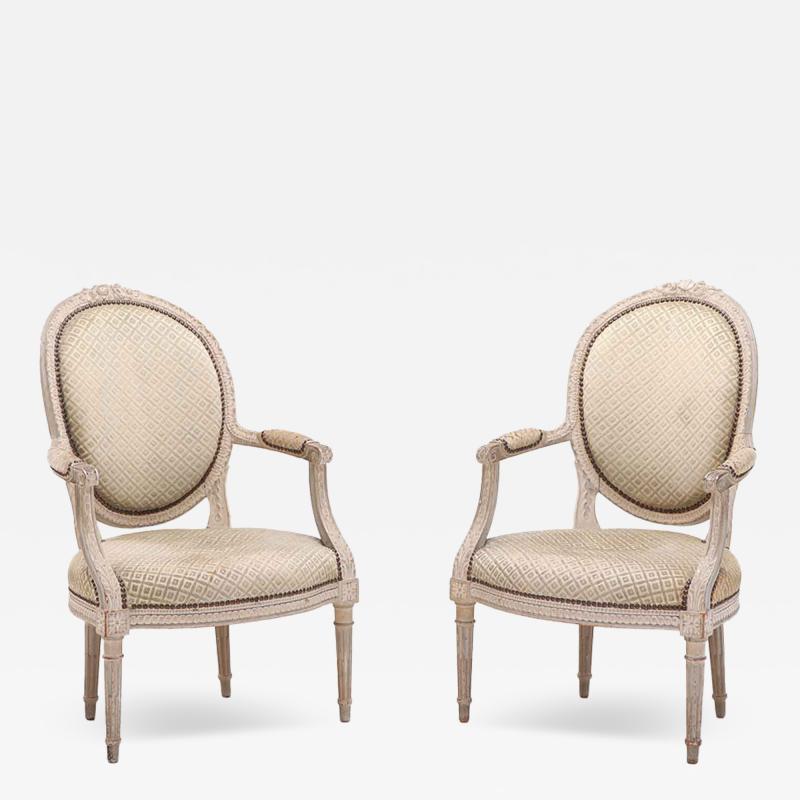 A pair of French Louis XVI style relief carved open armchairs circa 1860 