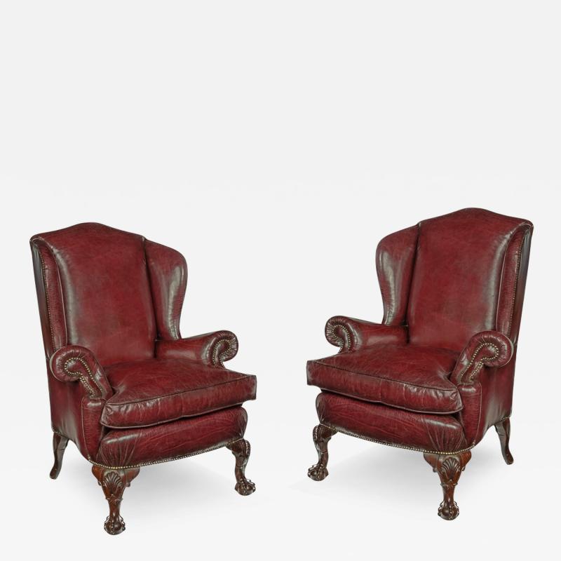 A pair of generous mahogany wing armchairs with shell carved knees