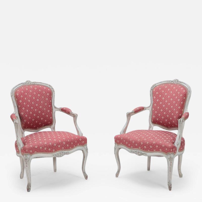 A pair of painted and carved French Louis XV style open arm chairs circa 1900 