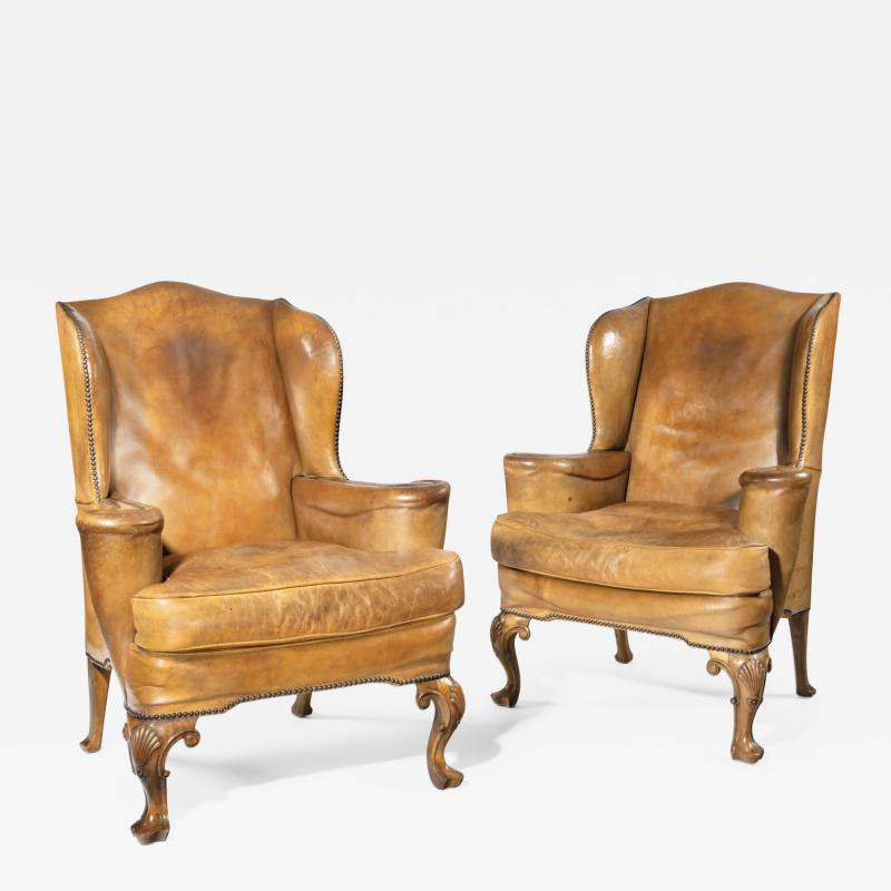 A pair of walnut wing armchairs in the Queen Anne style