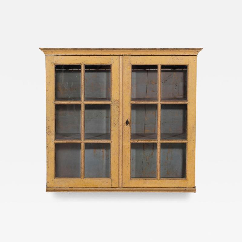 A period gustavian wall cabinet with glossed doors scraped to original paint