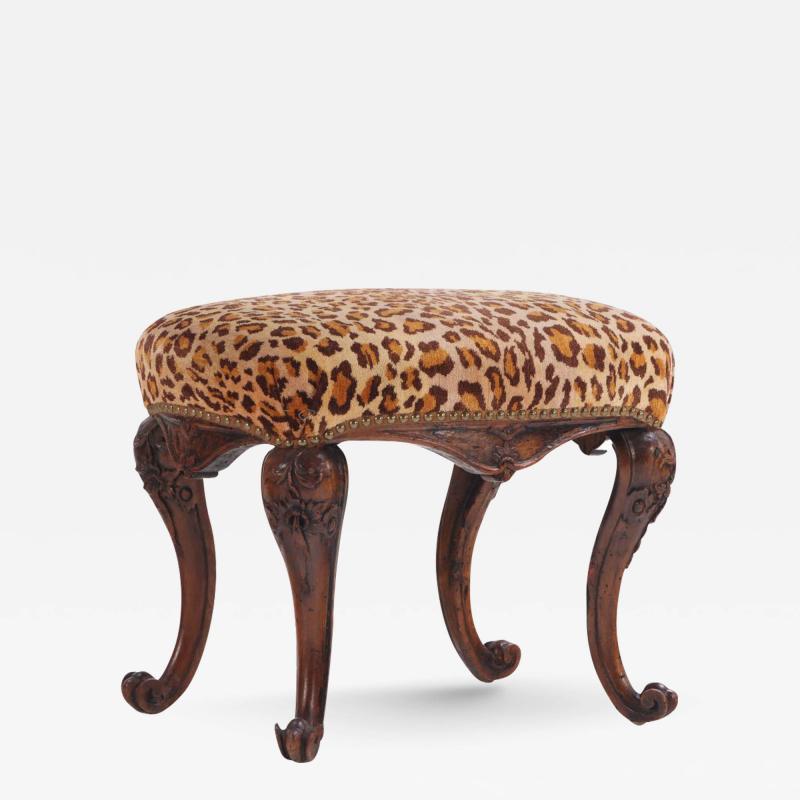 A petite Portugese carved walnut foot stool in the Rococo taste Late 18th C 