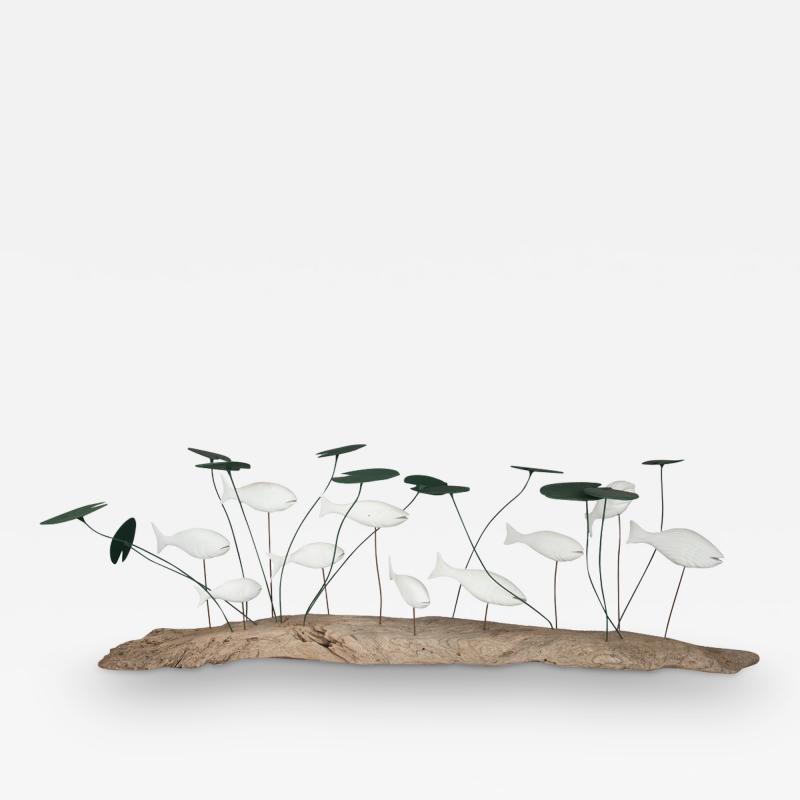 A wood and metal sculpture of a shoal of fish amongst lily pads by Martin Scorey