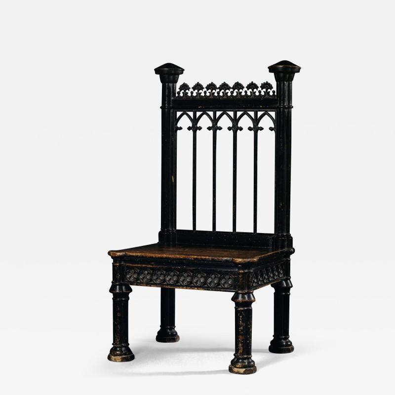 AN UNUSUAL MASSIVE EBONISED WOOD AND IRON CHAIR IN THE GOTHIC TASTE