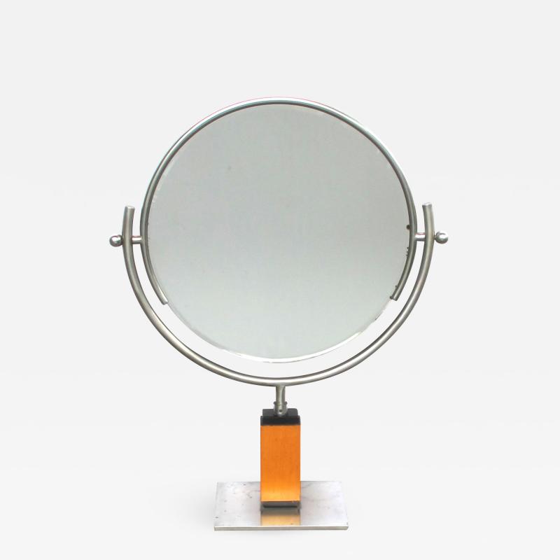 An American art deco steel dressing mirror raised on a maplewood base