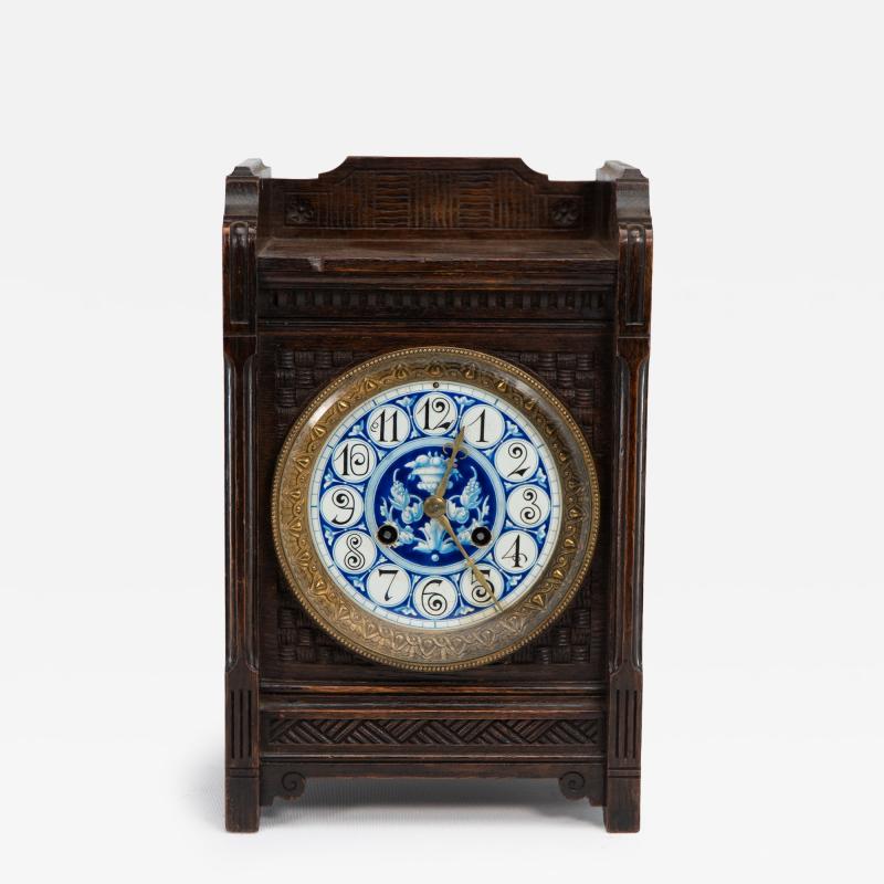 An Anglo Japanese Carved Oak Mantel Clock with Hand Painted Blue Floral Dial