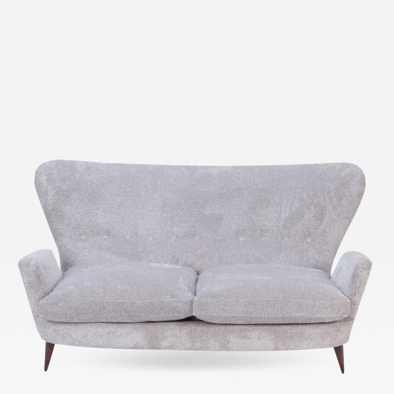 An Italian vintage wingback drop arm upholstered settee 