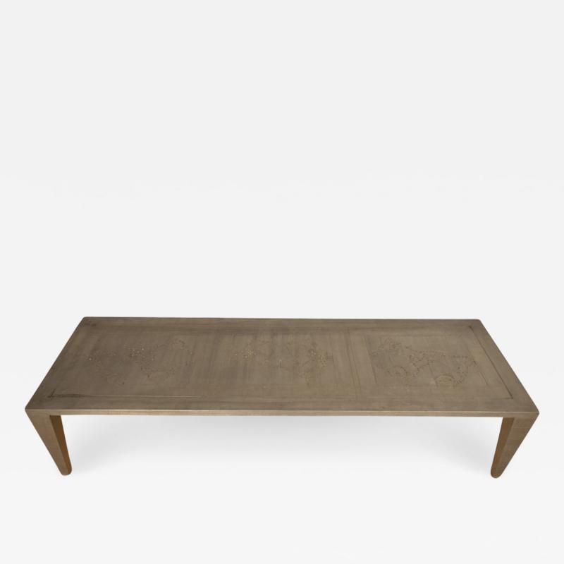 An artist designed metal clad silver color coffee table with holes in top