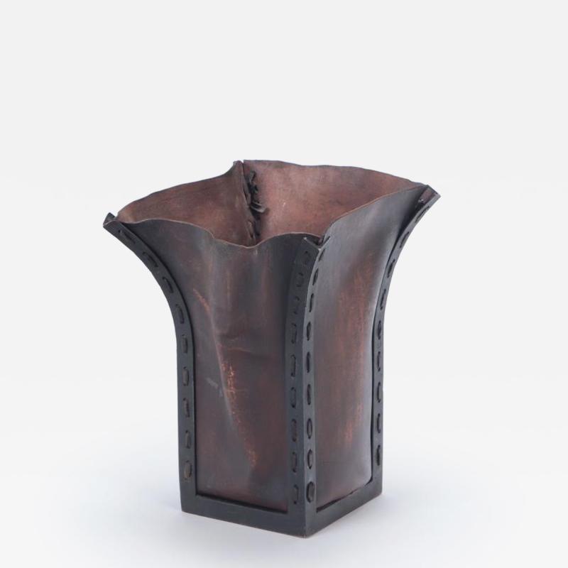 An iron and leather waste basket in the manner of Jean Michel Frank 