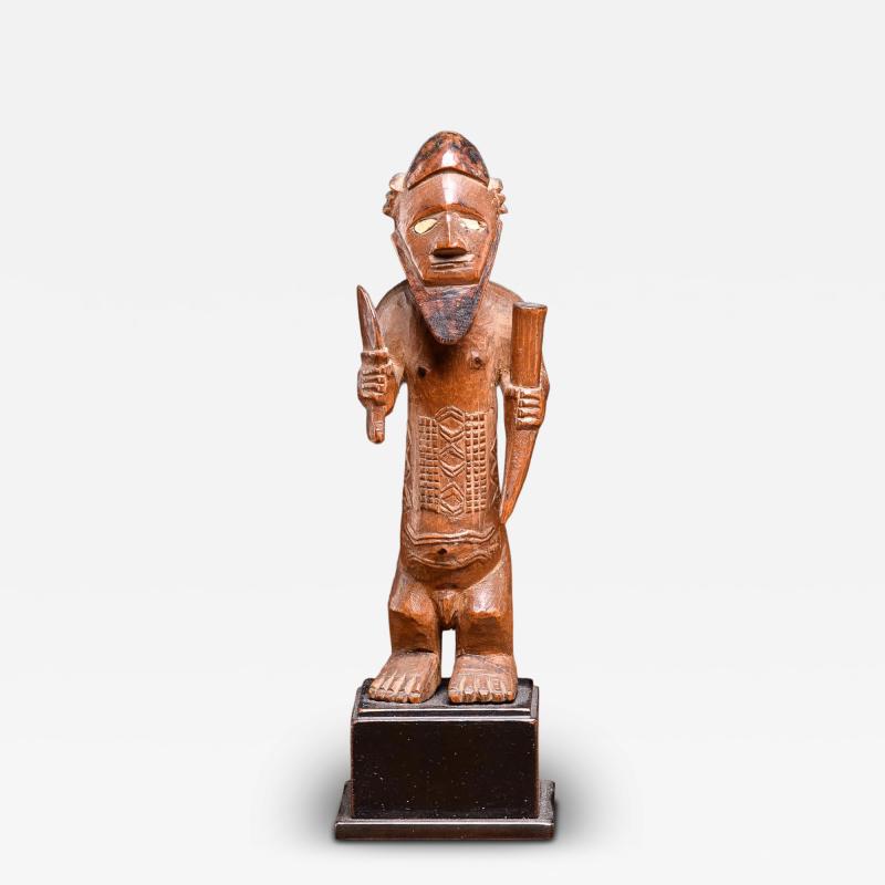 Bembe statue holding a knive and a horn