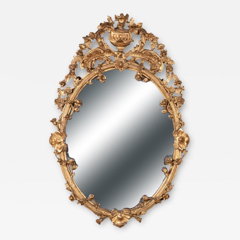 Carved French Giltwood Oval Mirror with Urn Crest Floral Garlands Circa 1870