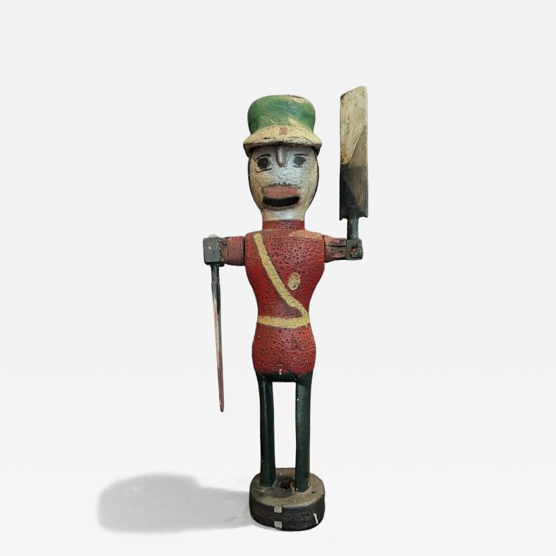 Carved and painted wood Whirligig of a soldier wearing red coat and a green hat 