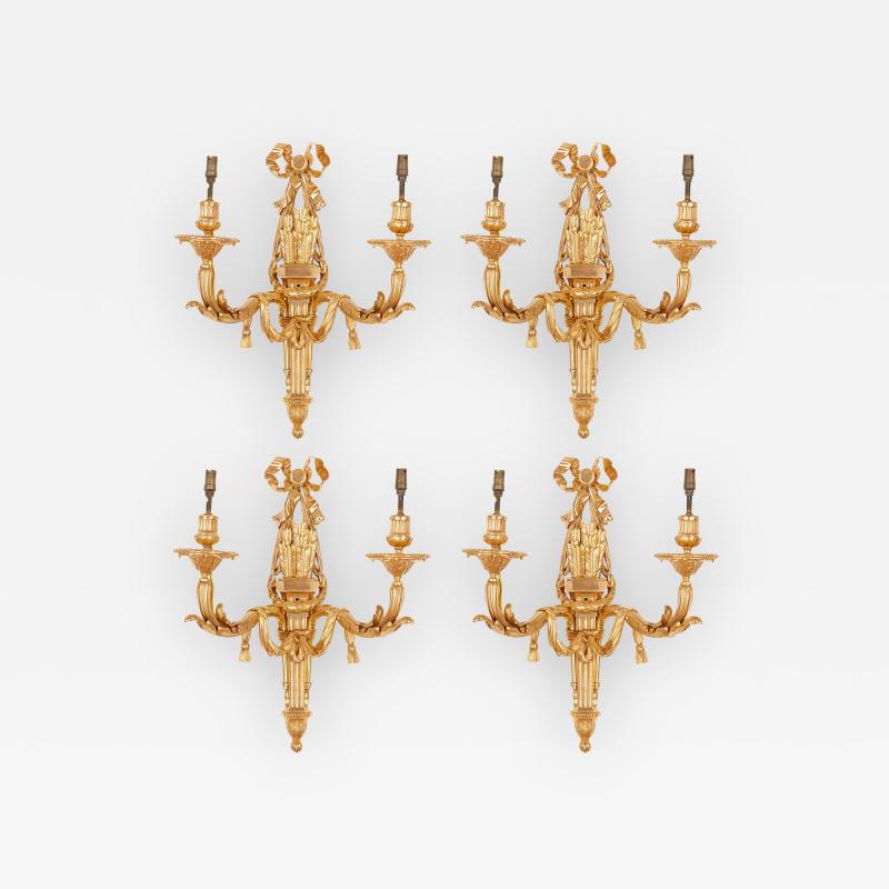 Four Neoclassical style gilt bronze two light sconces