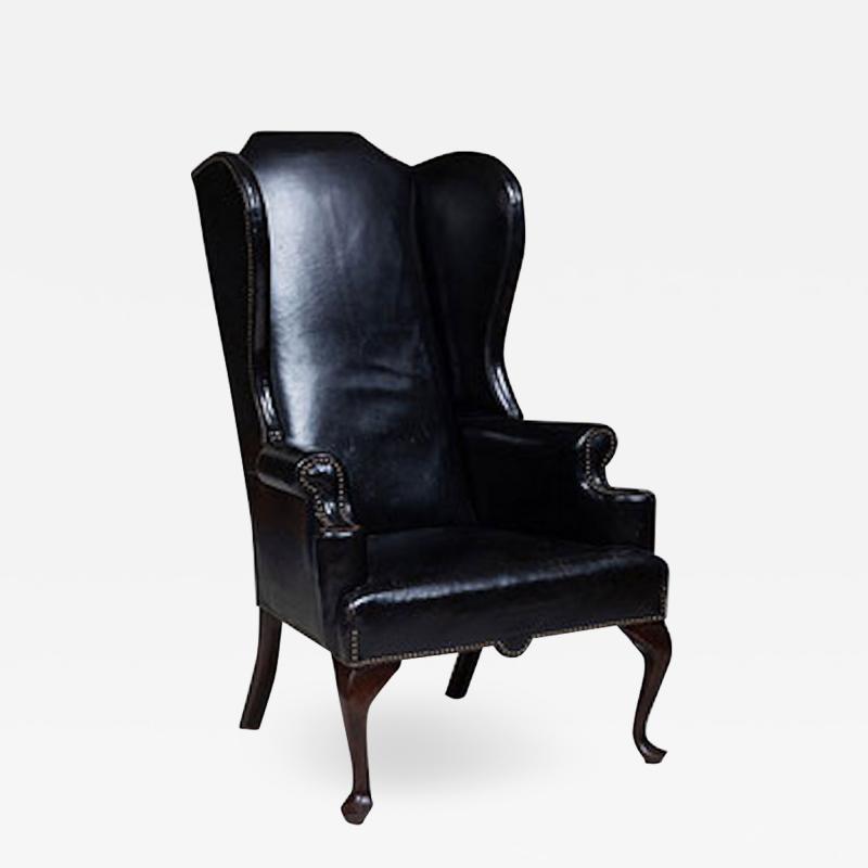 GEORGE II STYLE MAHOGANY AND BLACK LEATHER UPHOLSTERED WING CHAIR