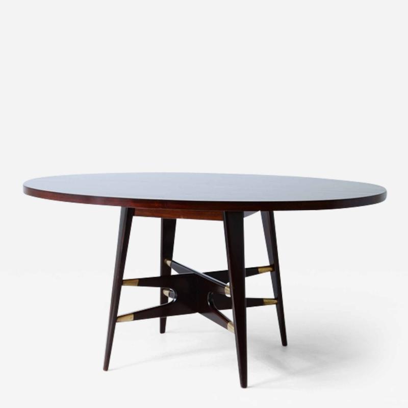Gianni Vigorelli Elegant oval table in stained wood with four legged uprights and important cross
