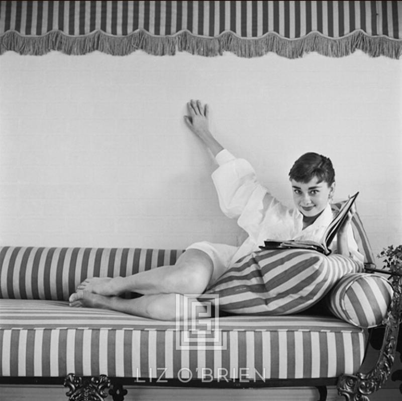 Mark Shaw Audrey Hepburn on Striped Sofa Reclines Hand Up Book Open 1954