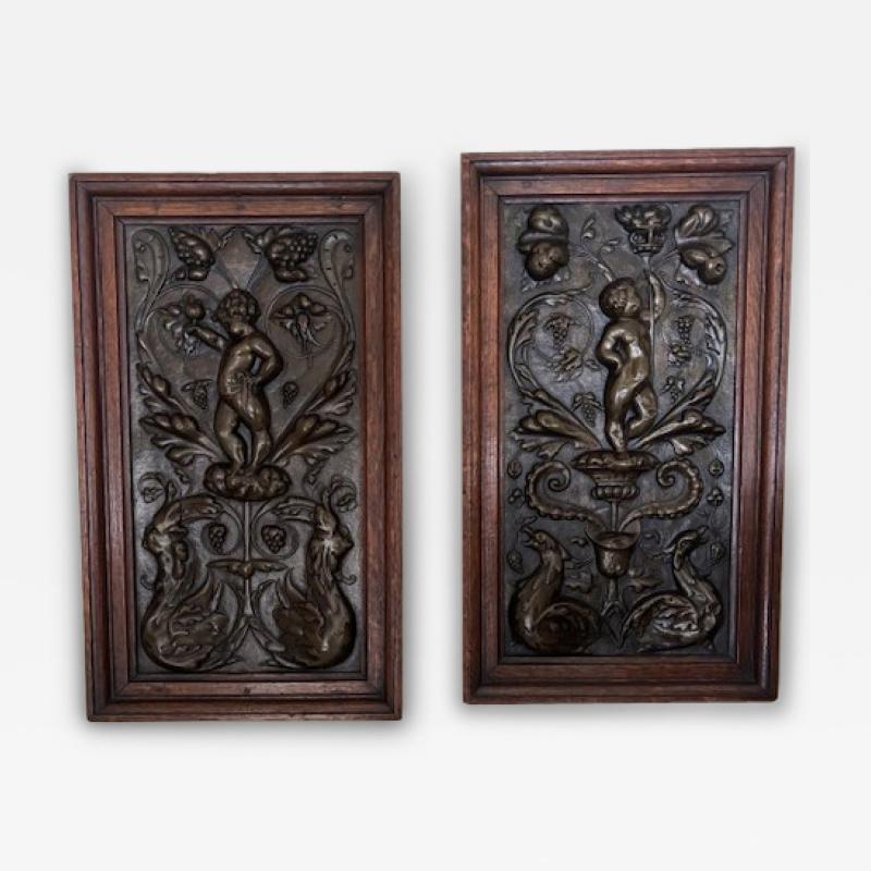 PAIR of French Victorian oak framed brass embossed cupid wall plaques