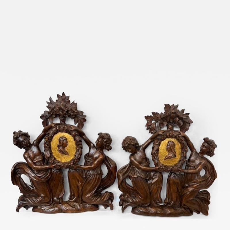 Pair of Italian wall plaques of 2 kneeling figures hold an oval frame portrait