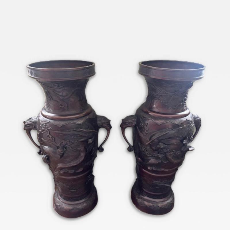 Pair of Japanese tall bronze floor vases with handles and bird relief