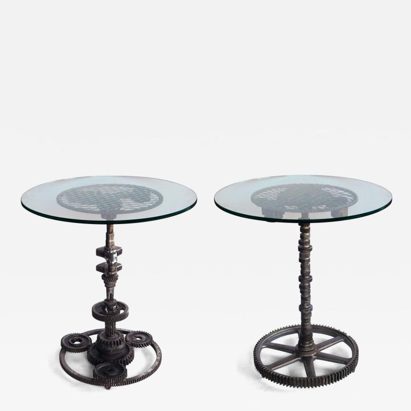 Pair of industrial cast iron gear wheel tables with circular glass tops