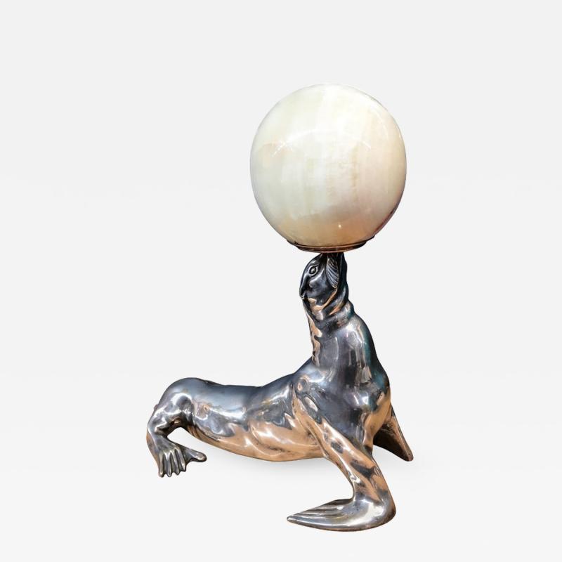 Silvered bronze illuminated sculpture representing a seal holding an onyx ball