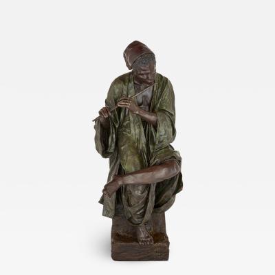  Goldscheider of Vienna A large painted terracotta figure of a boy playing the flute by Goldscheider