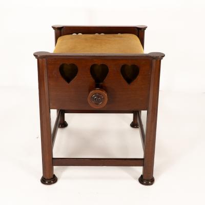  J S Henry J S Henry in the style of Voysey An Arts Crafts walnut adjustable piano stool