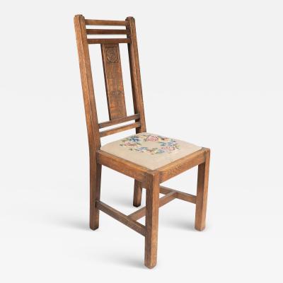  Liberty Co Liberty Co An Arts Crafts oak chair with carved rose decoration to the back