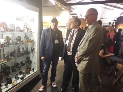 Steven and Leon Weiss of Gemini Antiques (left, right), with a collector (far left) in front of their booth.