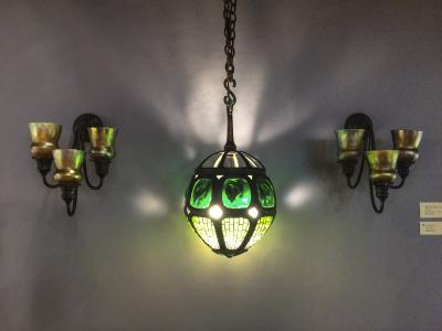 A rare and stunning hanging Tiffany lamp, flanked by a pair of favrile sconces, was offered by Lillian Nassau, who has historic photos of this or a similar lamp hanging at Tiffany