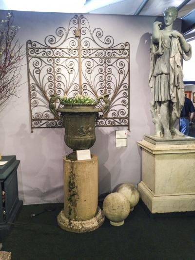 An elaborate iron gate, garden urn, and statue offered by Barbara Israel Garden Antiques.