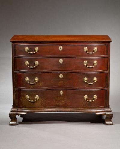 A FINE CHIPPENDALE OXBOW CHEST OF DRAWERS