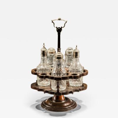 A FLAT DIAMOND CUT SUITE OF CRUET BOTTLES IN MAHOGANY STAND