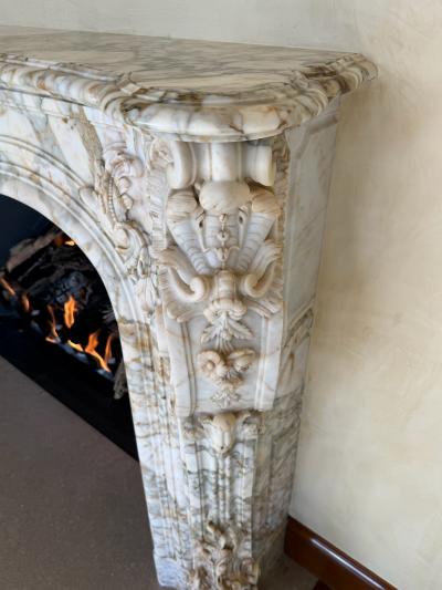 A Finely Carved Louis XV Style Fireplace Mantel in Figured Italian Marbl