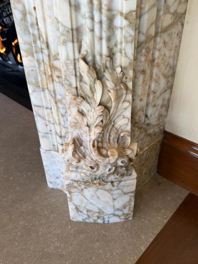 A Finely Carved Louis XV Style Fireplace Mantel in Figured Italian Marbl