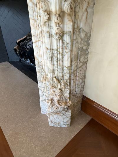A Finely Carved Louis XV Style Fireplace Mantel in Figured Italian Marbl