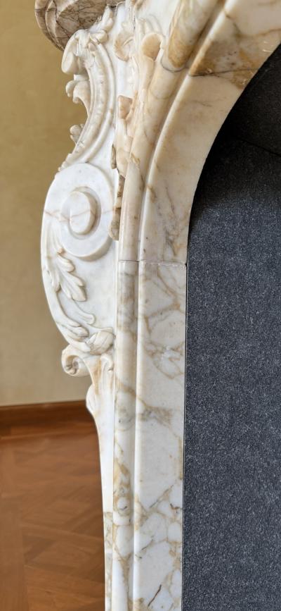 A Finely Carved Louis XV Style Fireplace Mantel in Figured Italian Marbl