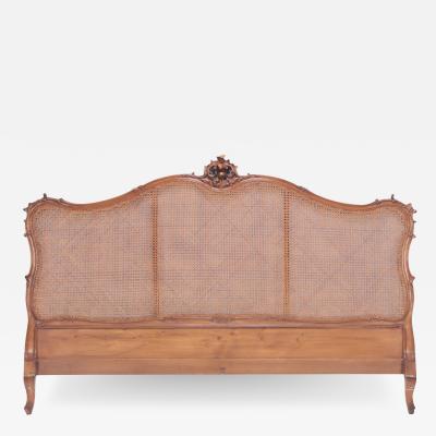 A French Louis XV style king size cain head board with carved crest Circa 1940 