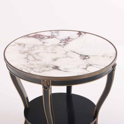 A French round marble top ebonized and gilt table C 1940 